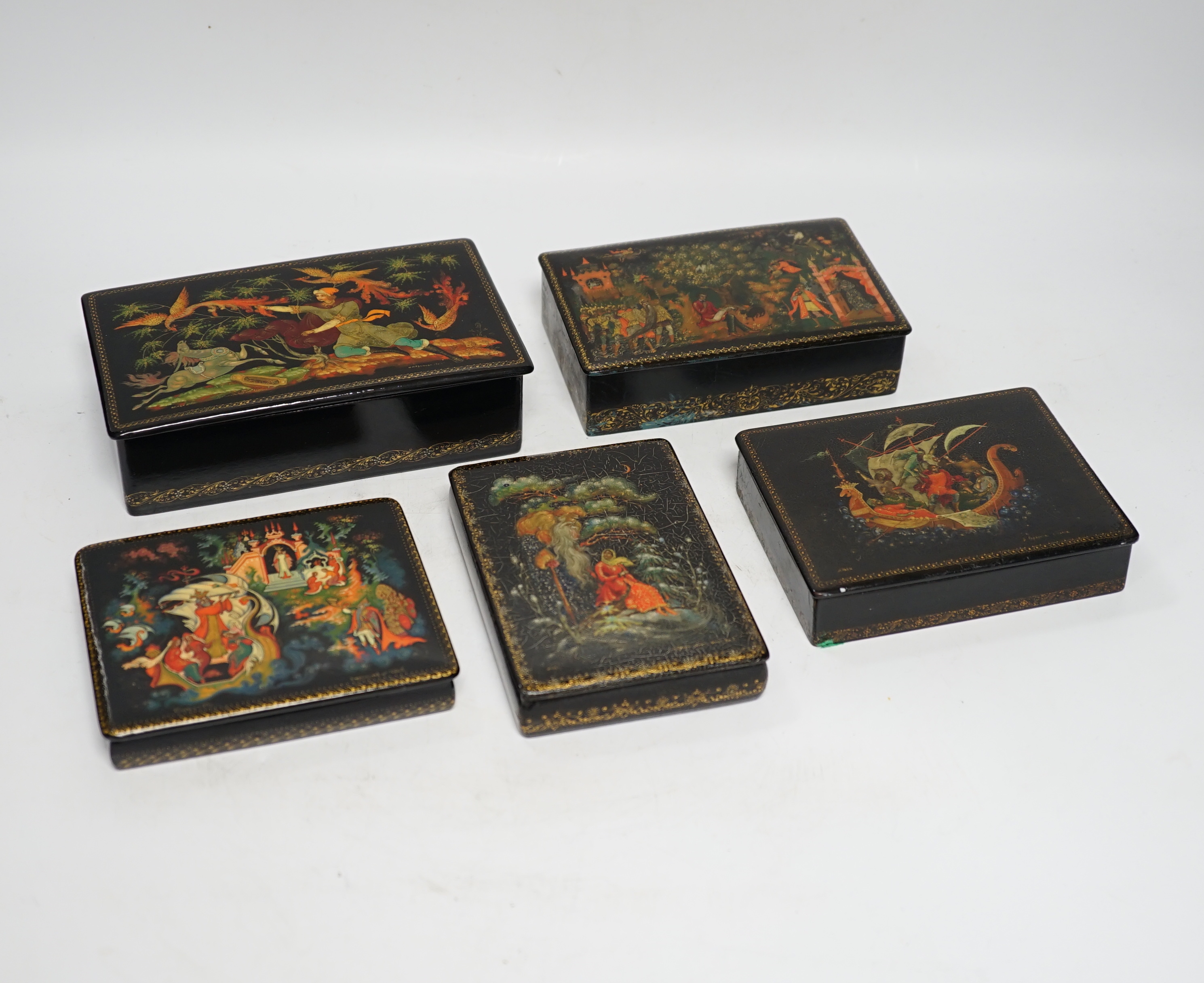 Five Russian Palekh lacquer table boxes, each painted with figures from legend, each signed by the artist, the largest 17 cm wide